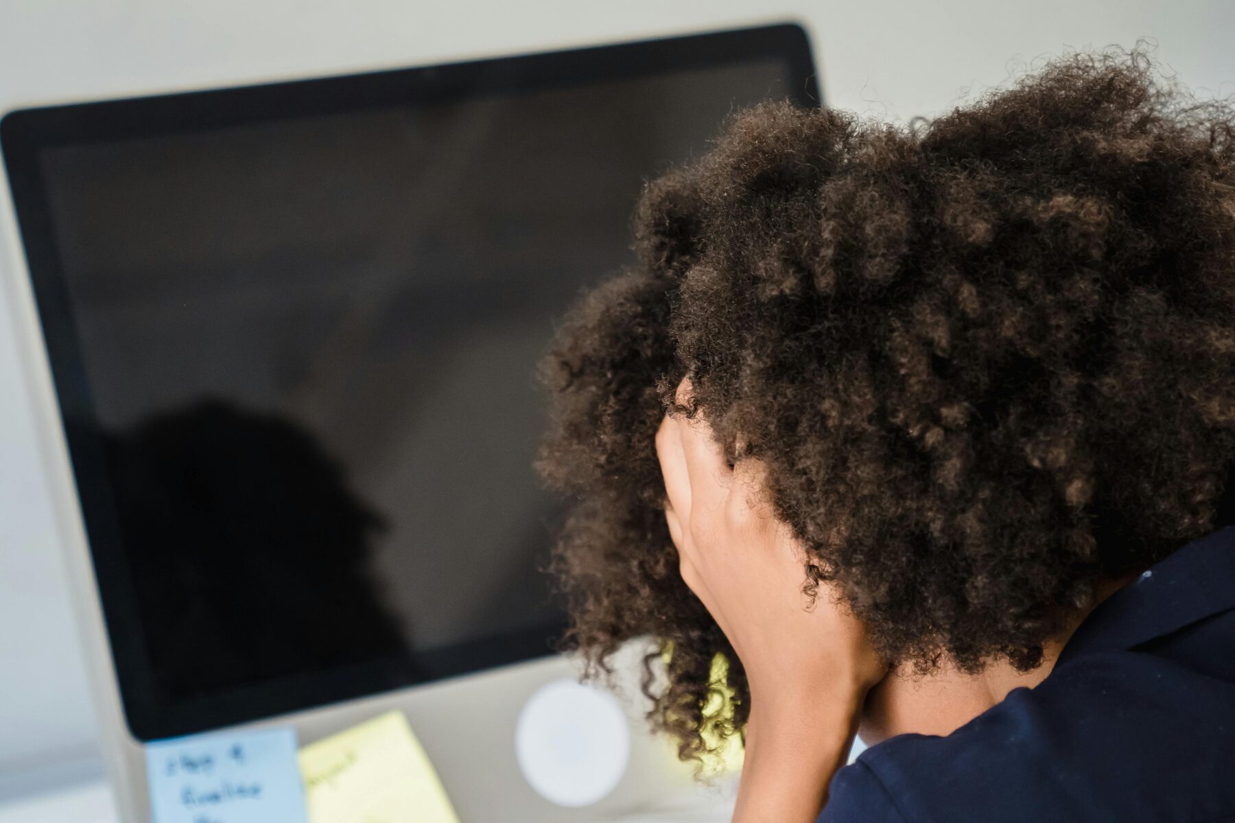 Violences sexuelles au travail. Une femme se prend la tête devant son ordinateur.